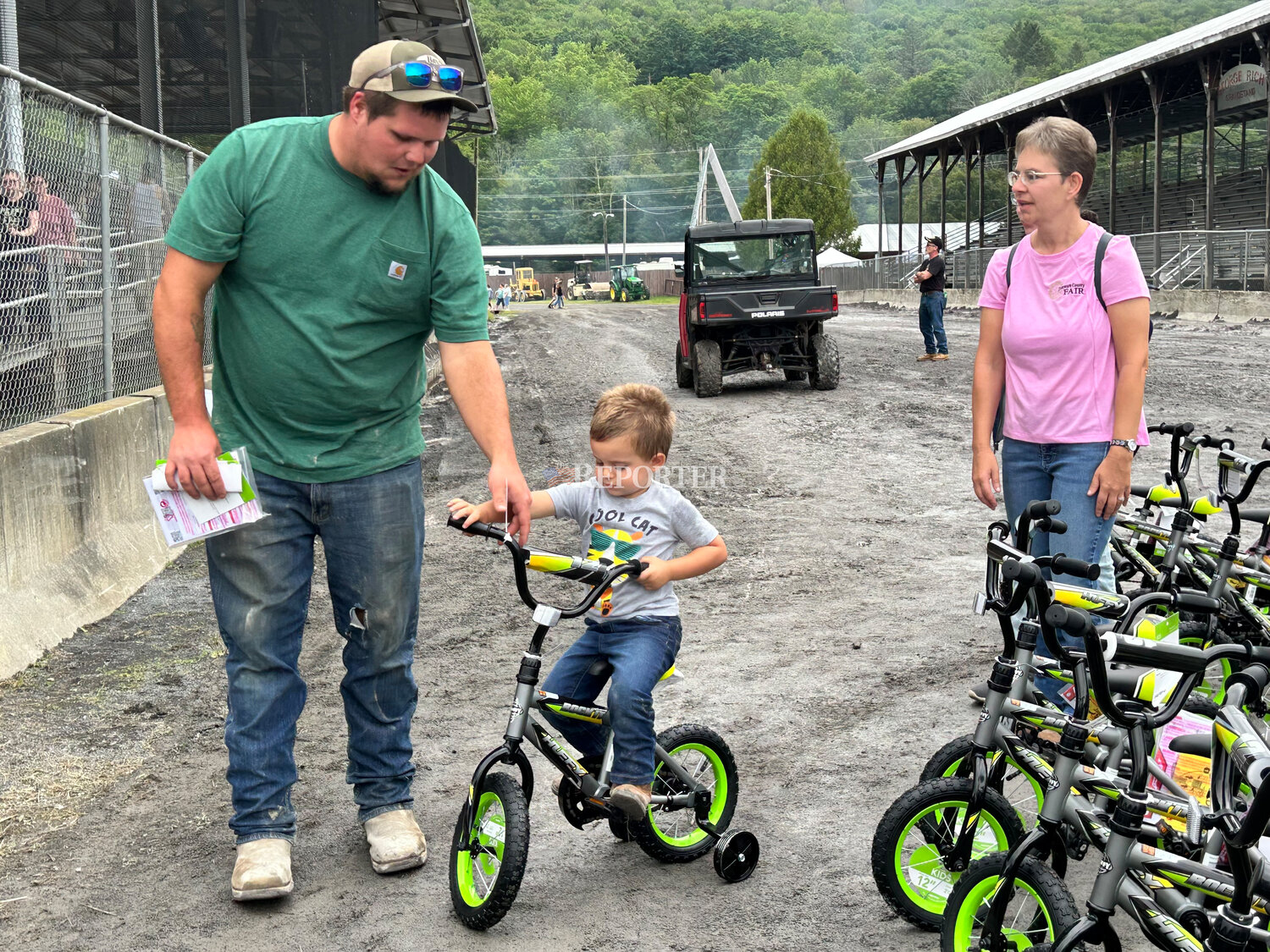 Timothy Lacey and his son Weston ride away after winning a 12 inch bike at the bike raffles, Tuesday, Aug. 15.